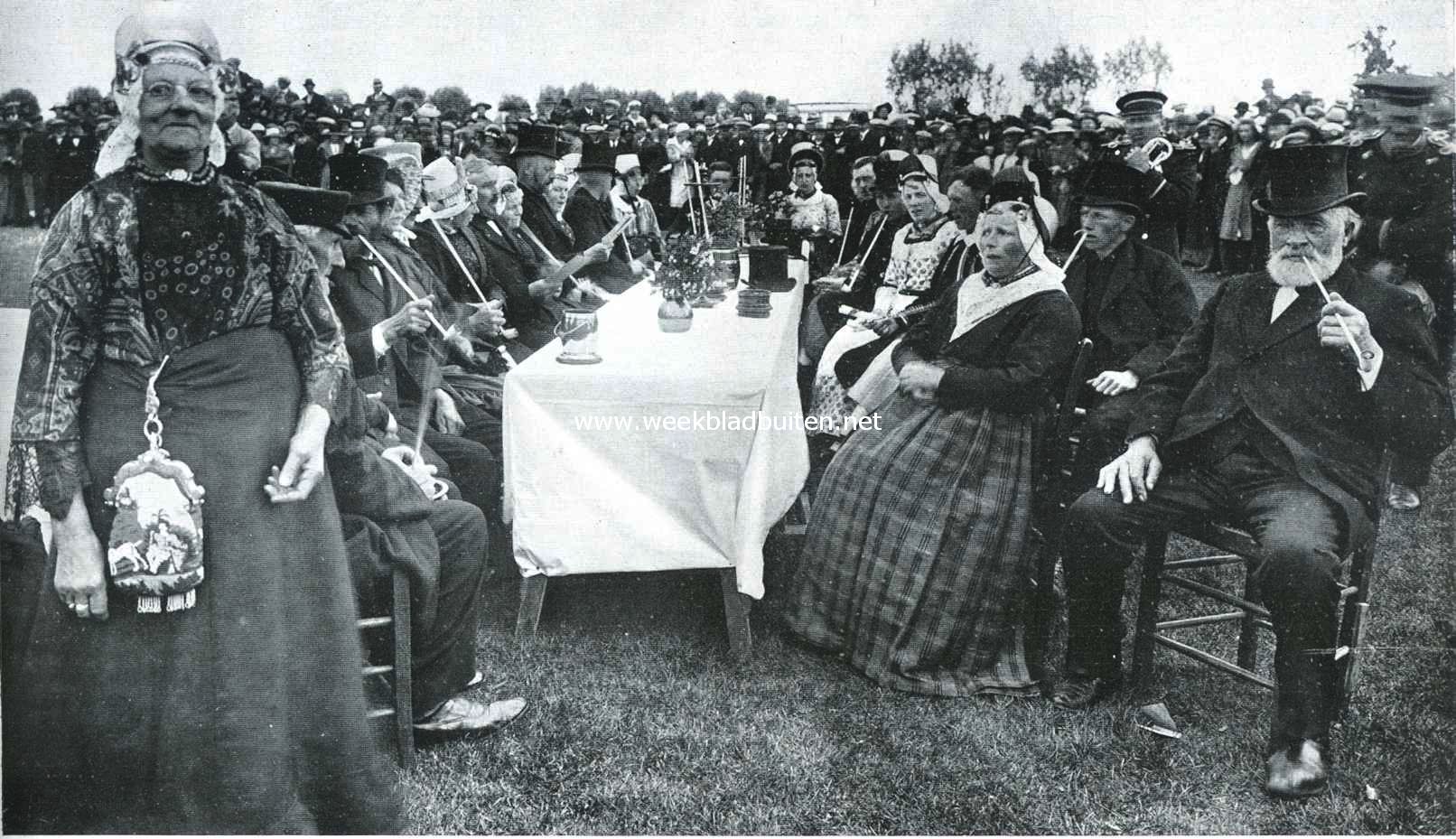 De bruiloftstafel van de ouderwetsche boerenbruiloft. Rechts in 't midden de bruidegom en bruid. Links op den voorgrond de overgrootmoeder van den bruidegom