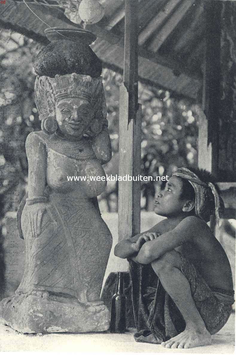 Bali. Jongen, kijkend naar een tempelbeeld
