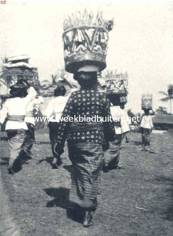 Lijkverbranding op Bali. Vrouw met fraai bewerkte offermanden van lontarblad