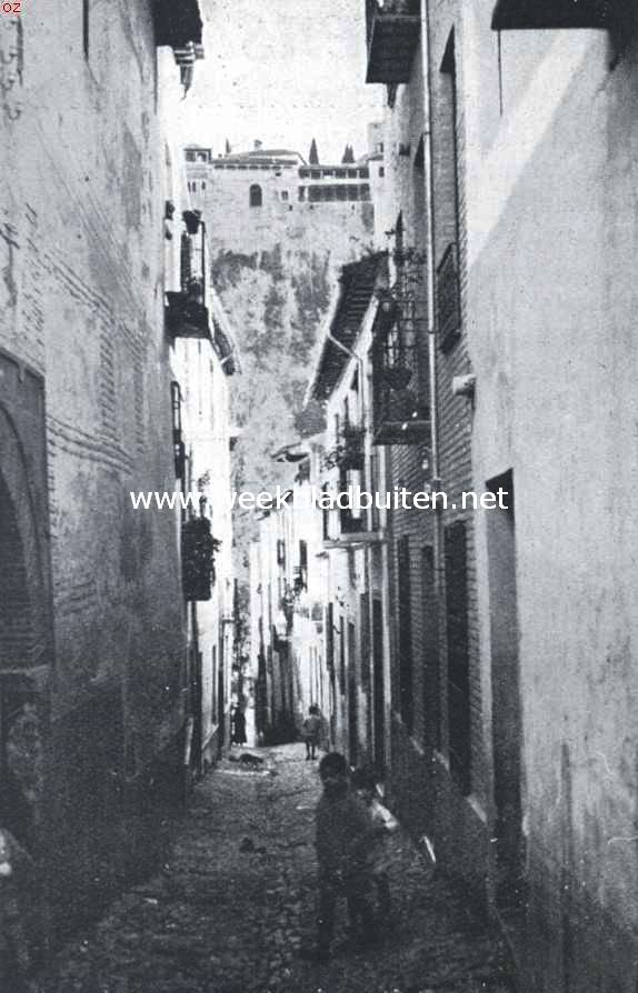 Granada, Spaansche vreemdelingenstad. Straatje in het Albaicin te Granada. Op den heuvel het Alhambra