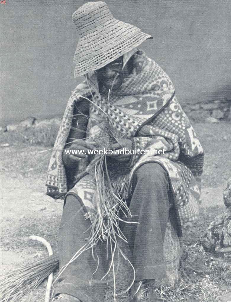Basoetoland, het Zuid-Afrikaansche Zwitserland. Bosoeto-hoedenvlechter. Is de hoed gereed, dan zet de maker hem bij wijze van etalage op den andere, dien hij reeds op zijn hoofd heeft